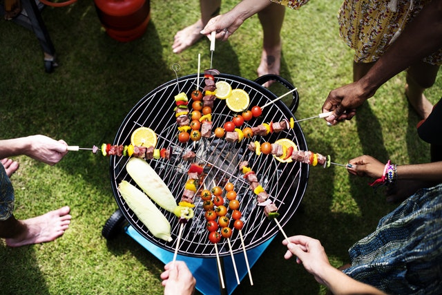 Picture of a group of friends barbecueing shish kabobs.