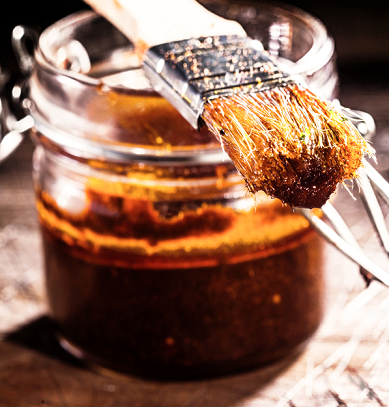 Picture of barbecue sauce in a jar with baster on top.