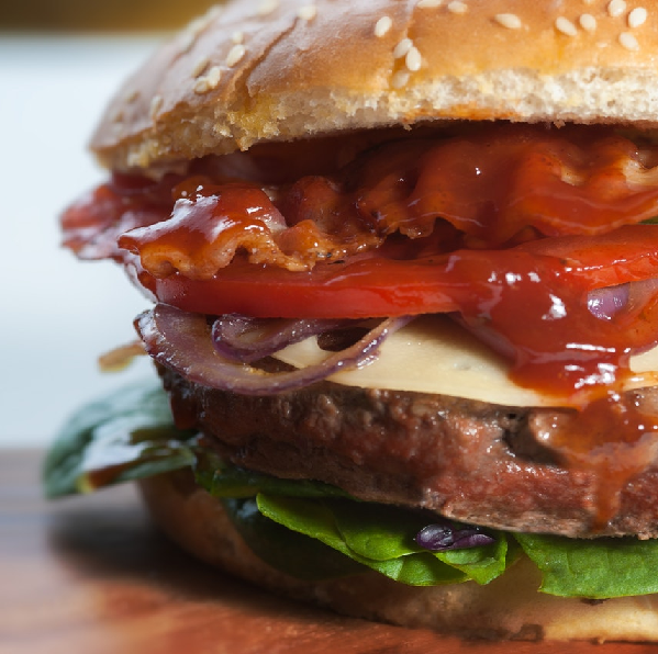 Picture of a hamburger with barbecue sauce on it.
