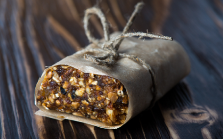 Picture of a fruit bar wrapped in grey parchment. 